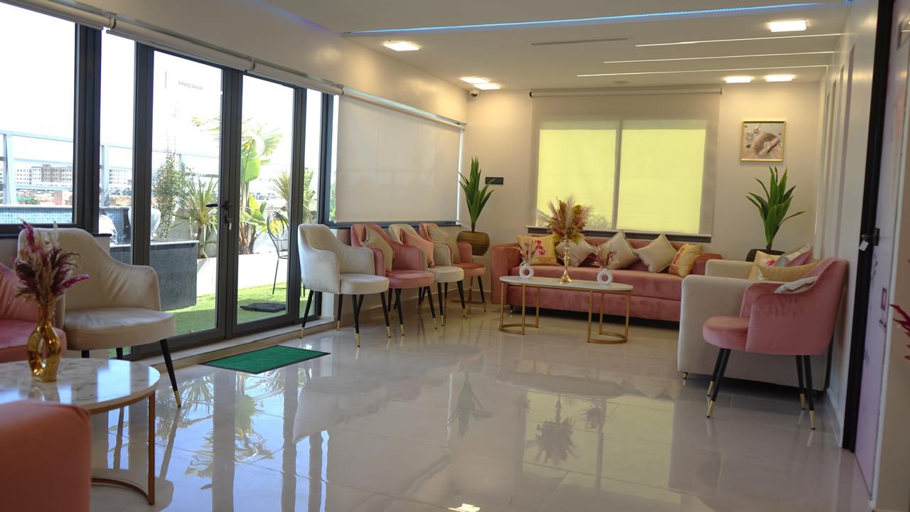 Salle d'attente spacieuse avec baies vitrées et terrasse végétalisée